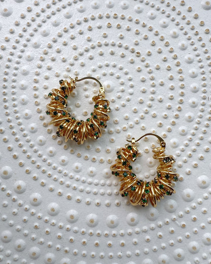 Chunky sculptural earrings with golden coils and green sparkle