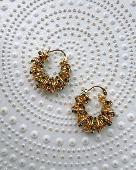 Chunky sculptural earrings with golden coils and green sparkle